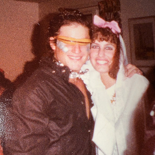 Kyle Greenberg wears a white veil with a pink bow next to her mock groom in a black jacket and orange sunglasses