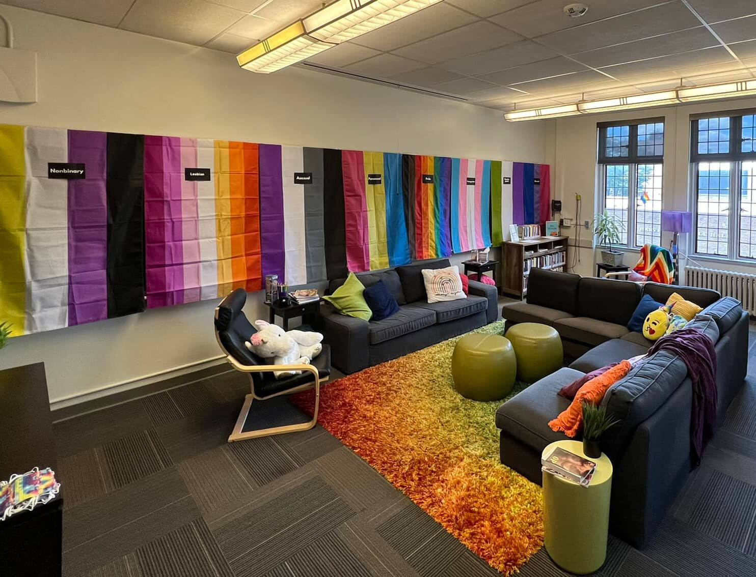 A room in the Pride Center, furnished with colorful, inviting decor, Pride flags, and comfortable seating.