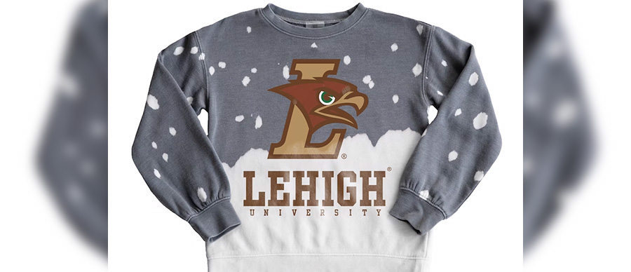 A gray and white crewneck sweatshirt; mimics snow falling from the top and piling at the bottom; features an L Hawk and "Lehigh".