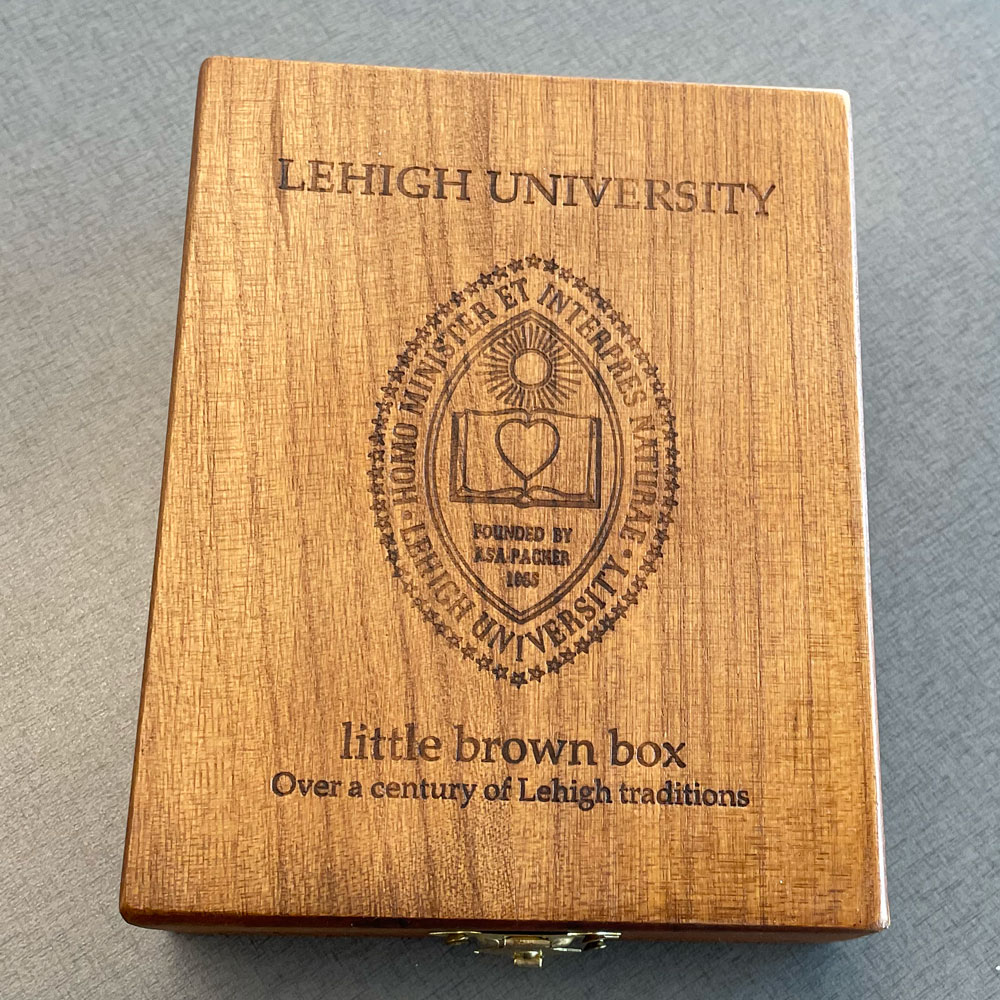 A wooden box with "Lehigh University Little Brown Box Over a Century of Lehigh Traditions" and the Lehigh seal etched into it.