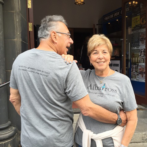 Michael and Enid Seiden wear gray t-shirts promoting Albatross, Michael showing the back and Enid displaying the front.