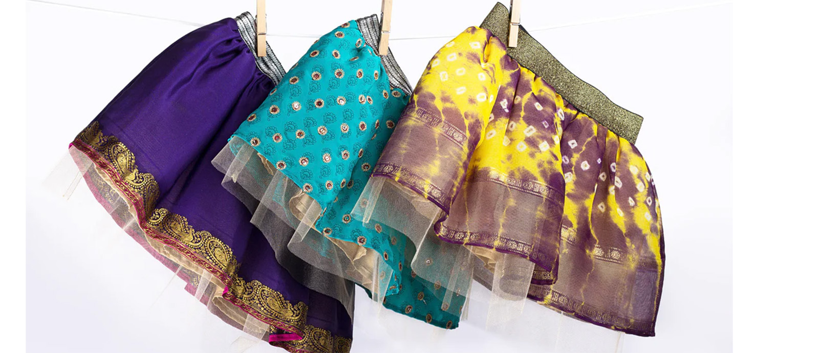 Three colorful children’s tutus hanging on a clothesline.