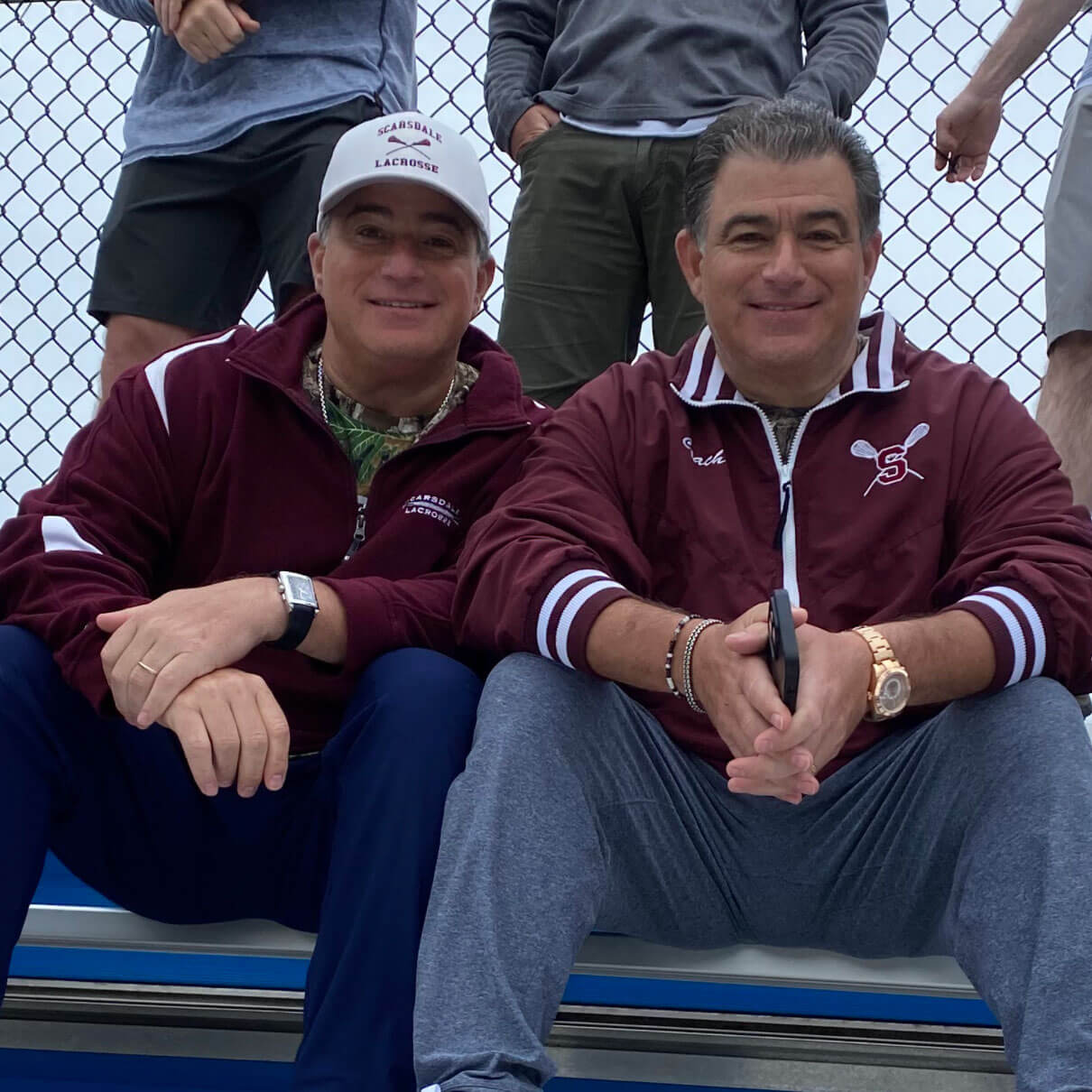 Brothers Neil and Jay Canell in the bleachers at a lacrosse game