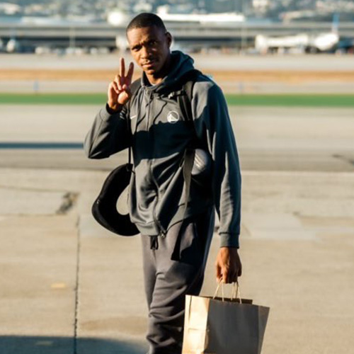 Noel flashes the peace sign on airport tarmac in Golden State Warrior gear