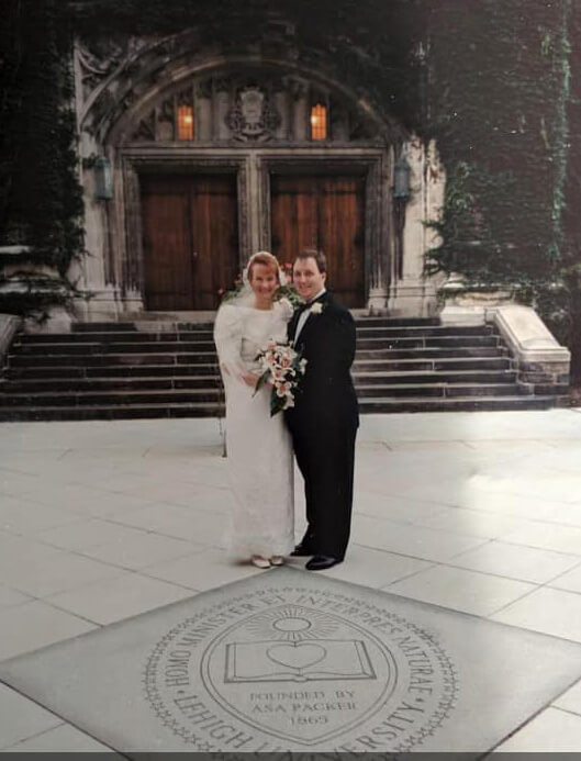 Bride and groom in the 1990s pose for a wedding portrait in front of Lehigh University landmark. 