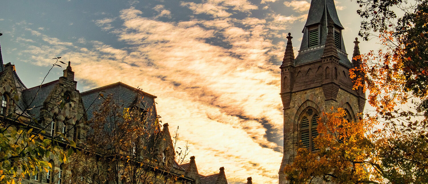 A campus beauty image of a stone building with a spire.