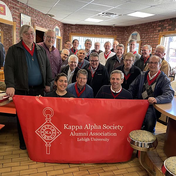 The Kappa Alpha Society poses with their banner inside Pete's Hot Dog Shop
