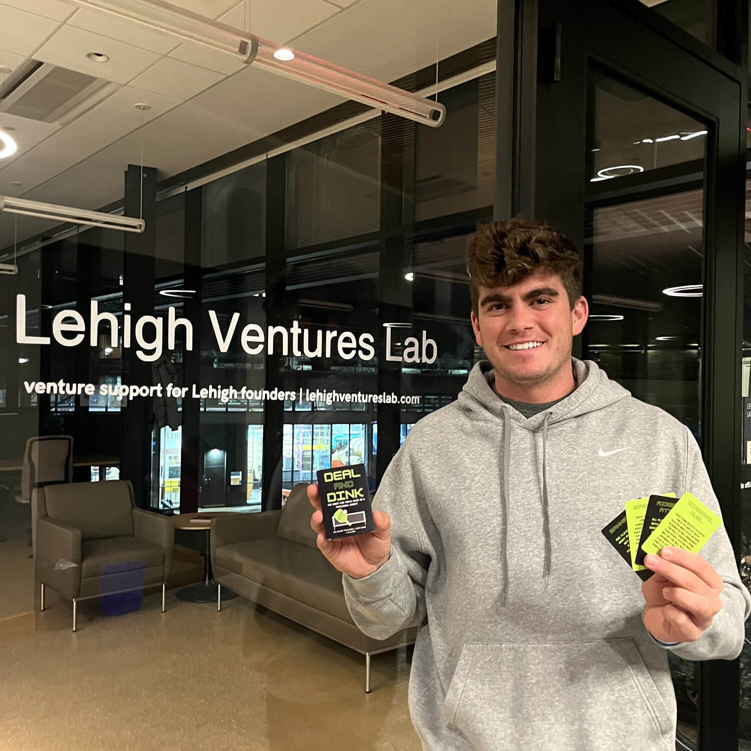 Kimball stands in front of the Lehigh Ventures Lab holding Deal and Dink in his hands.