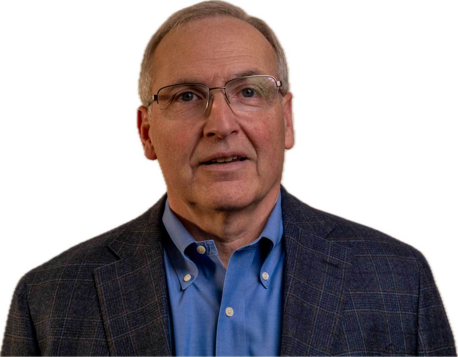 Kevin Kennedy smiling while wearing a tweed jacket and blue button-down shirt.