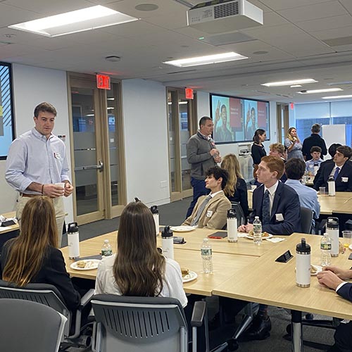 Lehigh alumni at PwC stand and speak to tables of Lehigh students