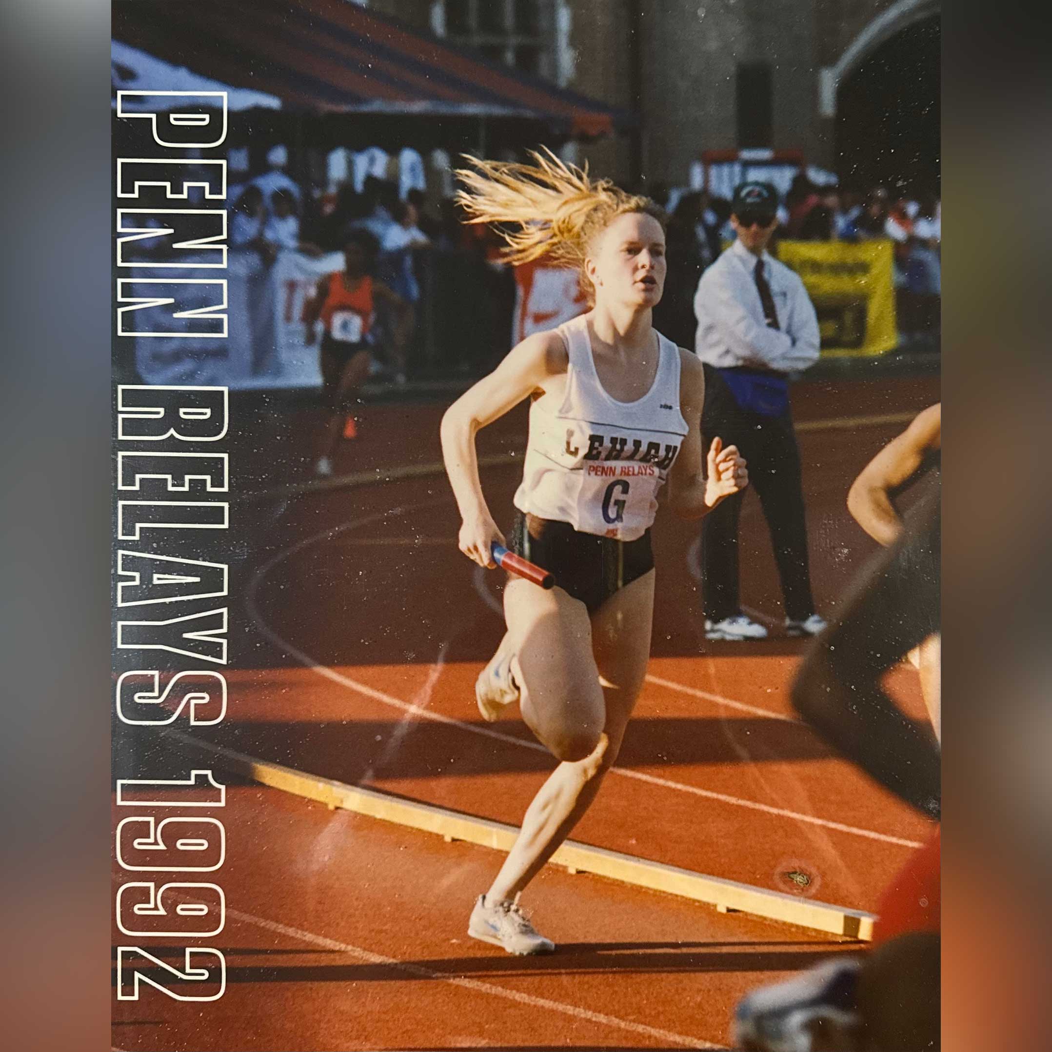 Bridget in a relay race in 1992. She wears a white and brown Lehigh jersey, holds the baton, and runs down a track.