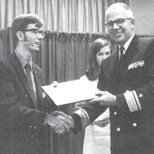 Ron Amey shakes the hand of a Navy leader