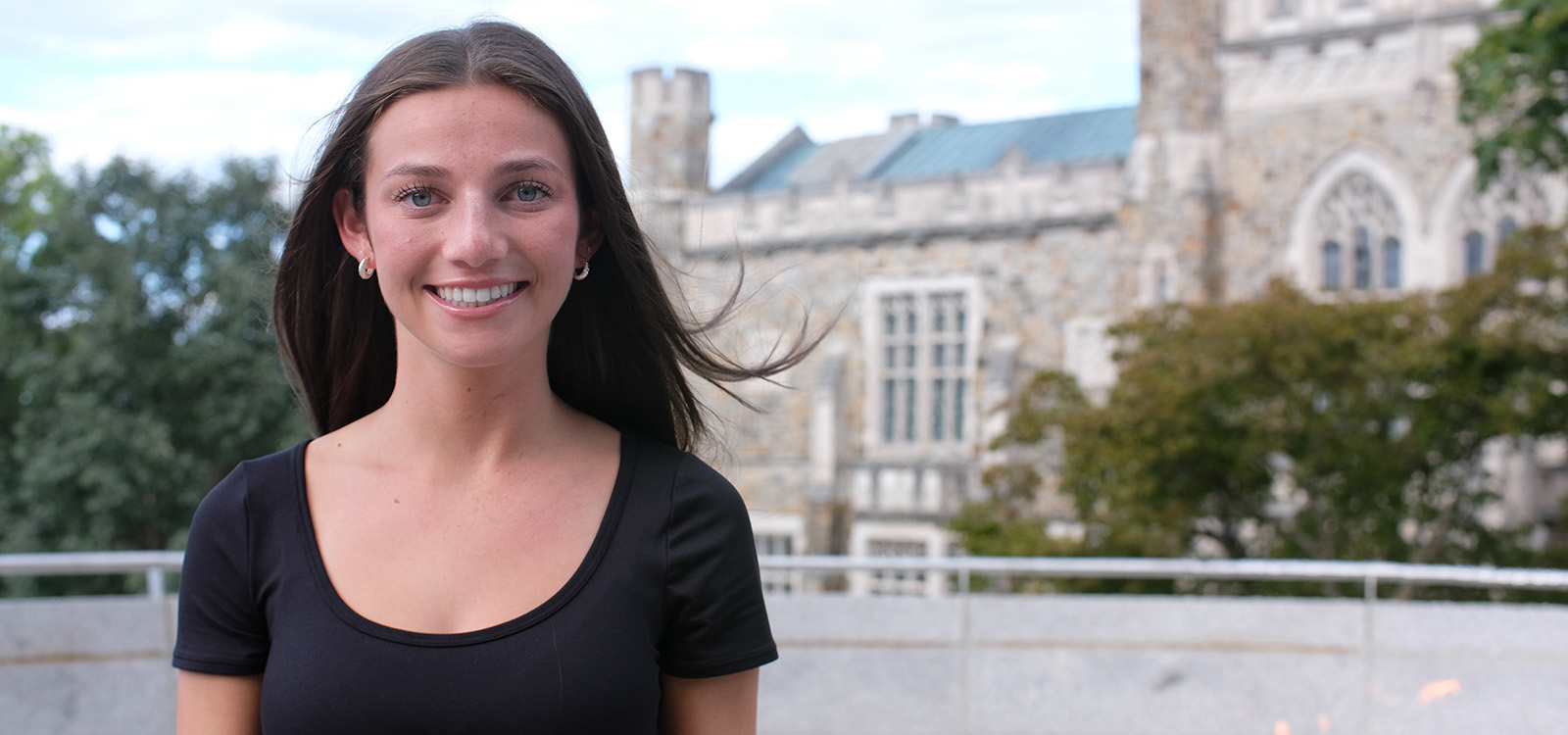 Lily Osias  stands near the fire pit with Linderman Library in the background
