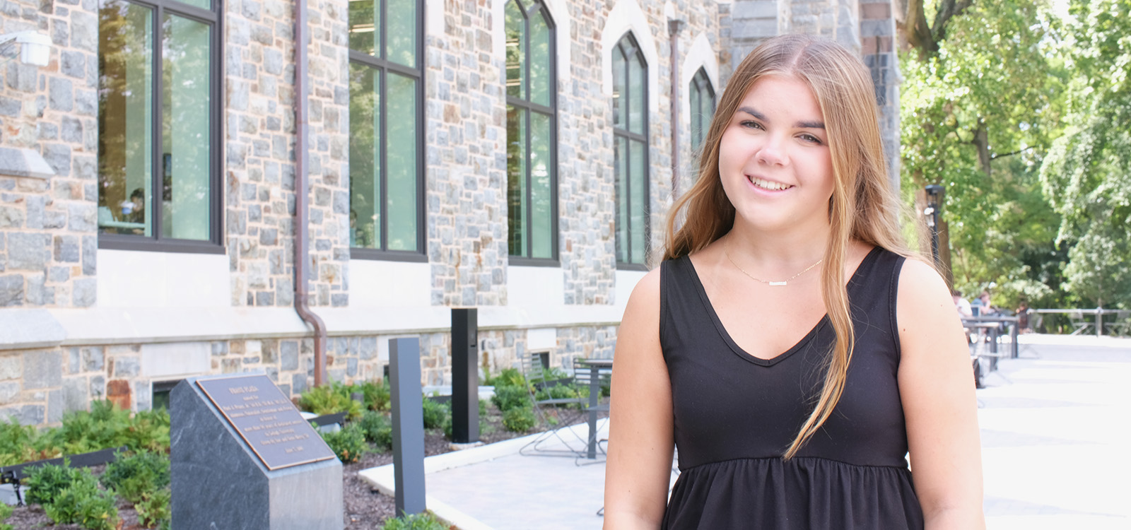 Riley Altman stands on the patio outside the Clayton University Center