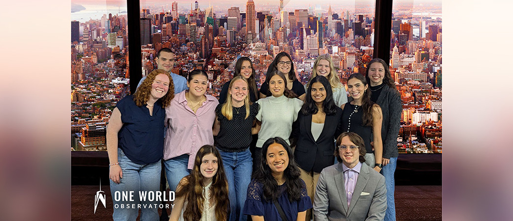 A group of scholars in front of a skyline.