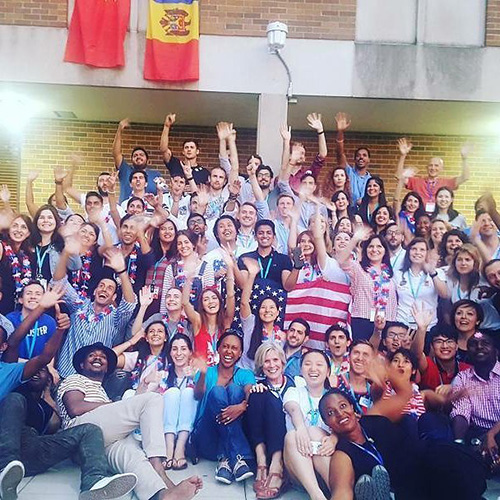 A group of international students with flags wave hello