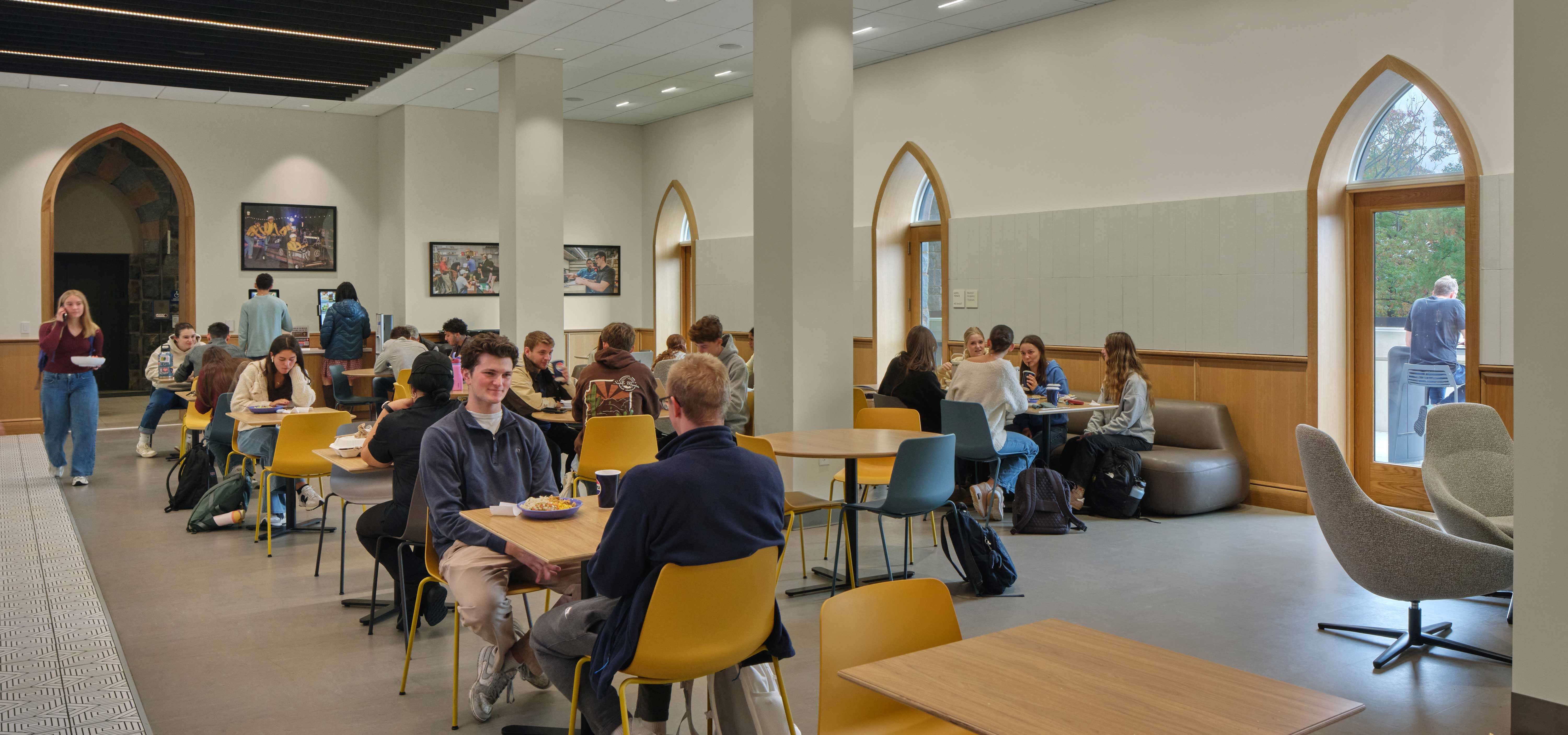 Students sit throughout the Crossing at different tables and on couches.