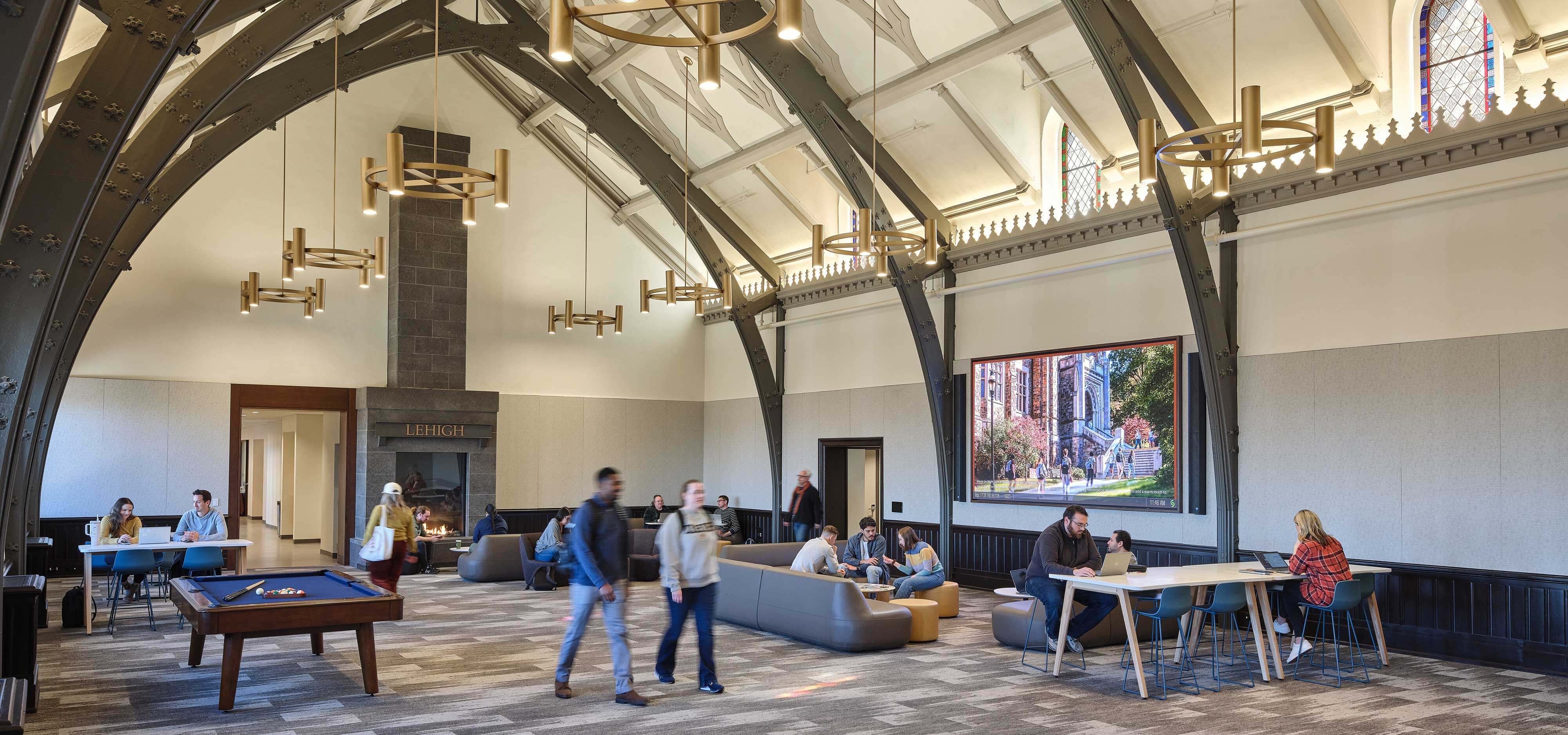 Students and professors occupy a space adorned with high arches.