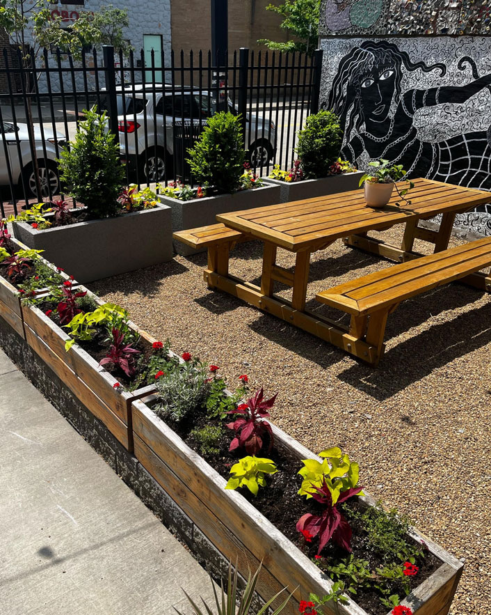 Two Frays outdoor picnic table surrounded by flower planters