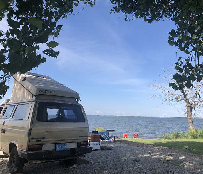 VW Bus parked for a lakeside picnic at a campsite