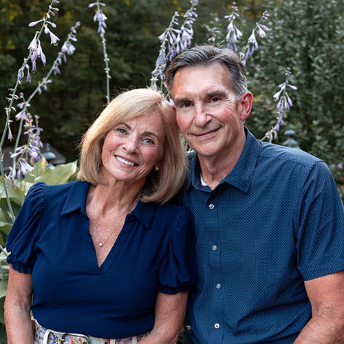 Marybeth and Andy Vandergrift wear blue shirts and stand side by side