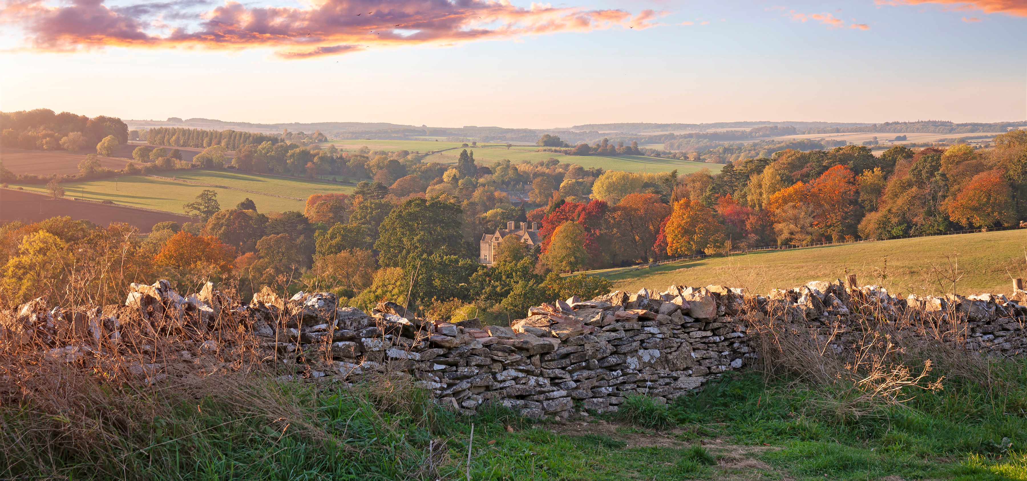 A rock wall overlooking rolling hills.