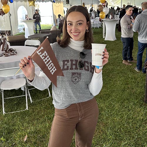 Caroline Weisstuch ’19 holds a Lehigh cup and pennant under the Rivalry tent