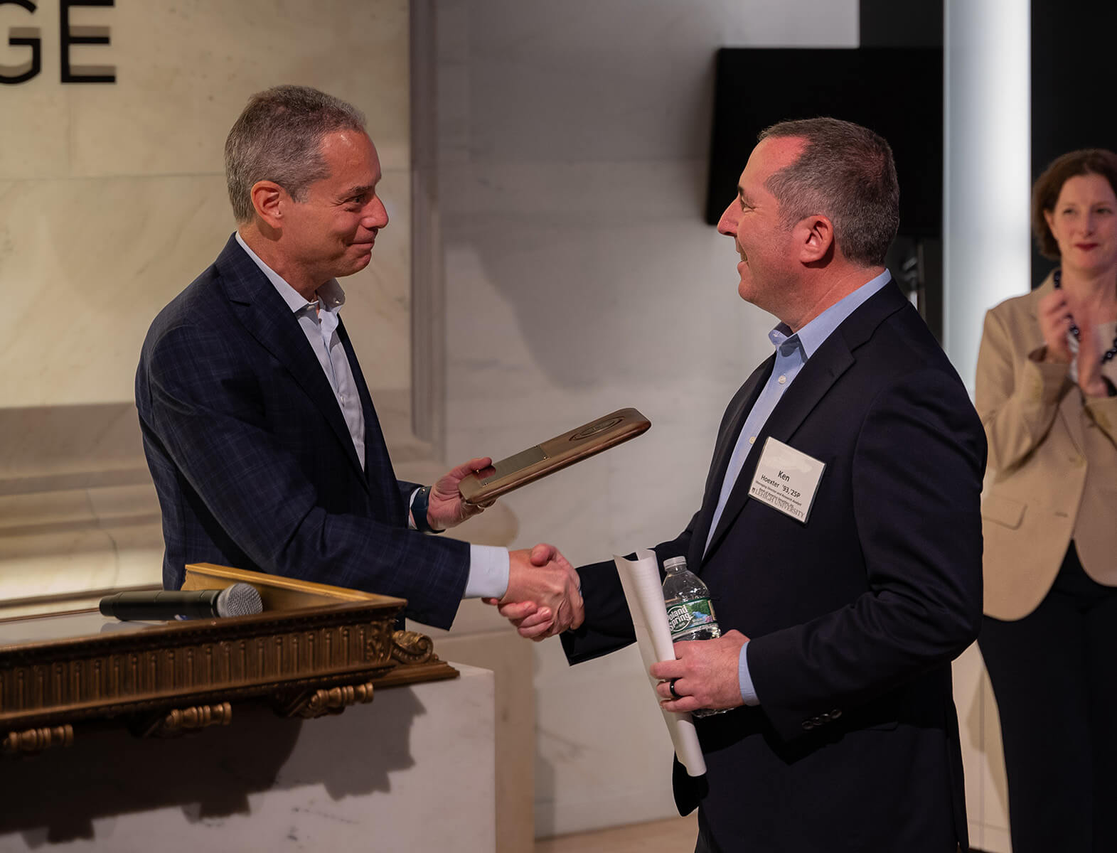 Ken Hoexter is handed a plaque as he approaches the podium at the New York Stock Exchange