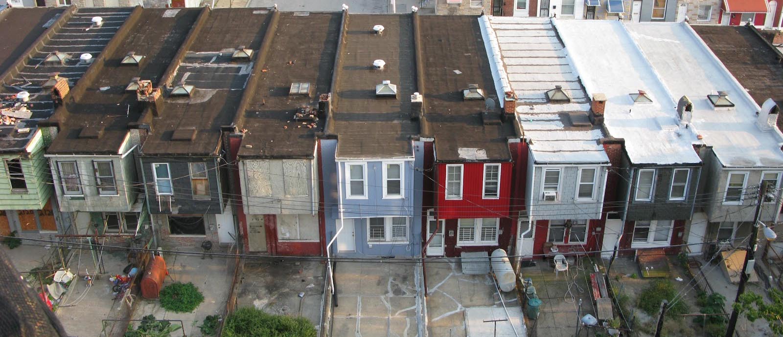 Three row houses have white roofs compared to the other houses
