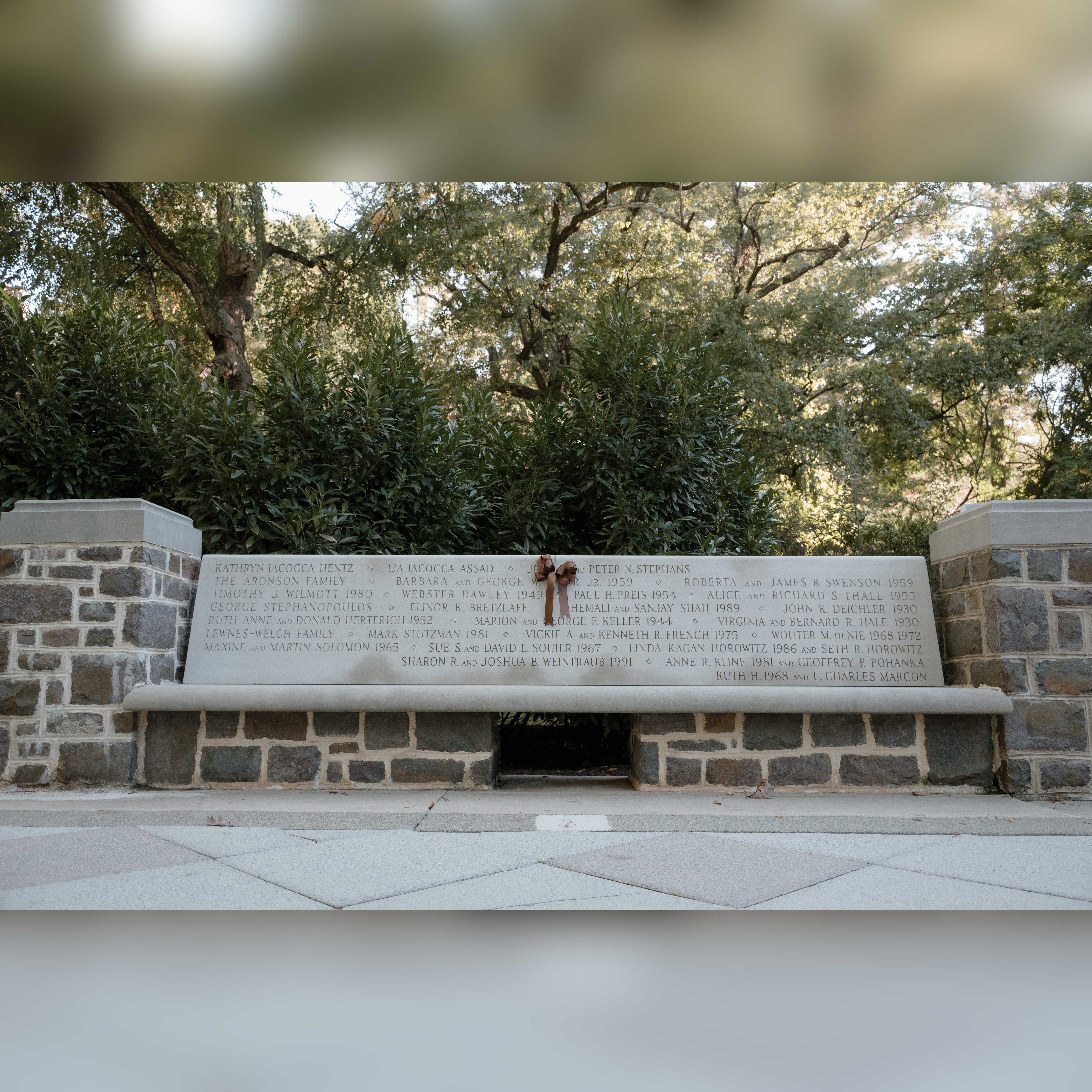 A photo of the engraved bench with a bow on it.