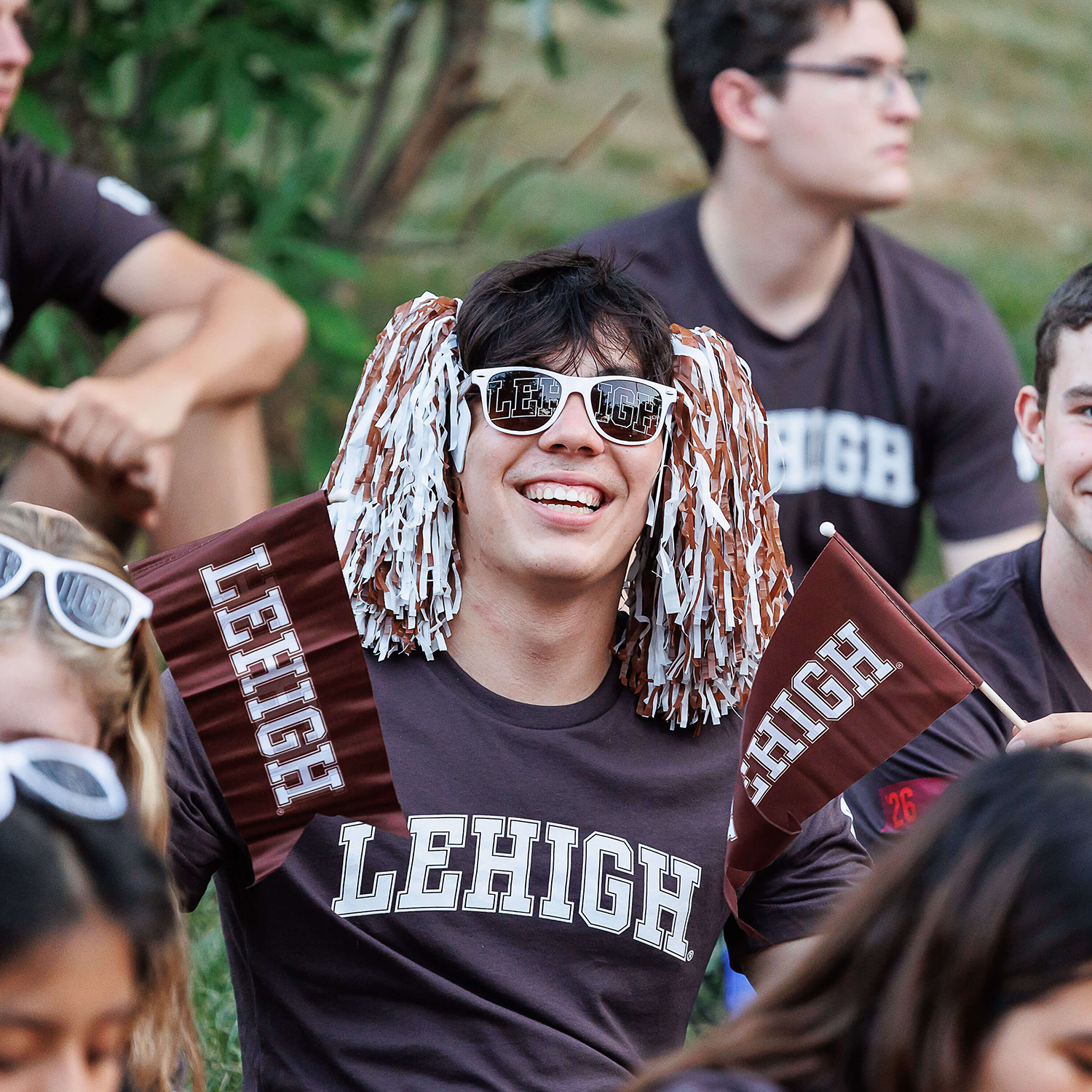 Lehigh students show off their brown and white with t shirts, flags, pom poms, and sunglasses.