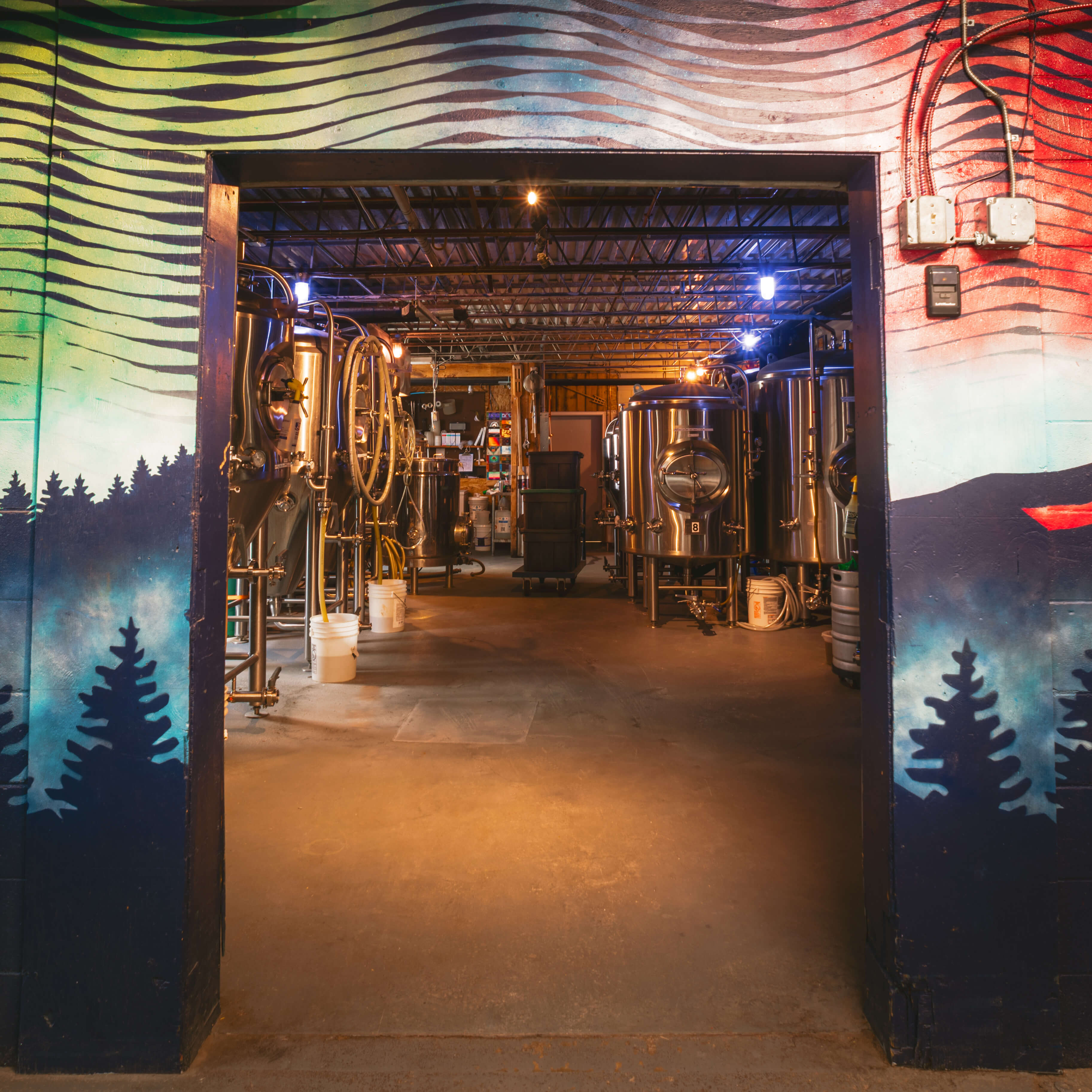 The interior of a brewery showcasing silver microbrew equipment