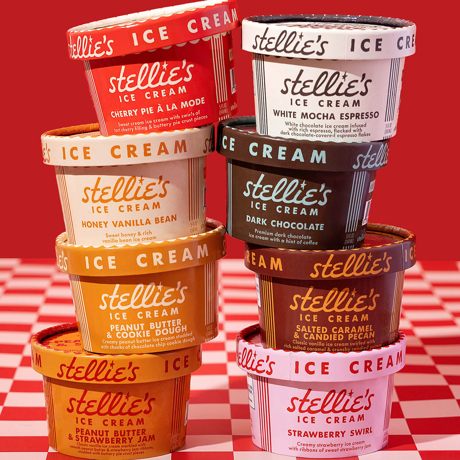 Eight colorful ice cream tubs are stacked in two columns against a red and white checkered surface.