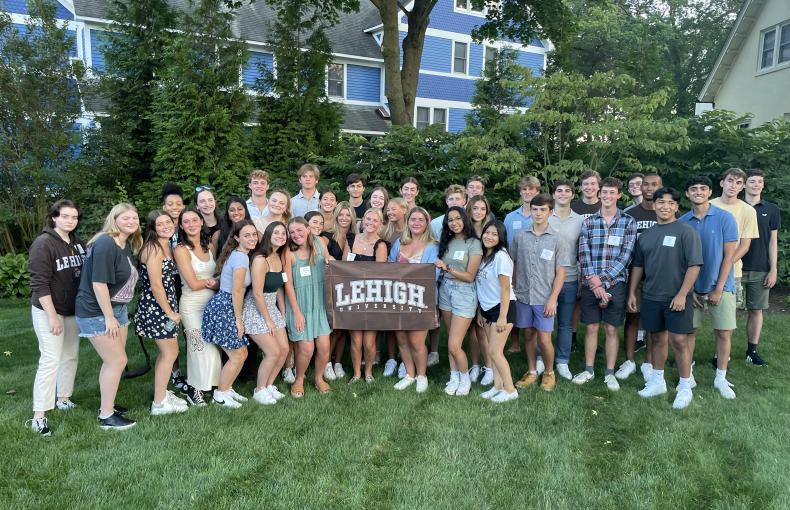 A group of students with a Lehigh University flag.