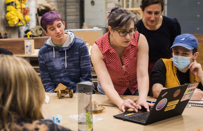 Lehigh professor with students gathered around her looking at a laptop