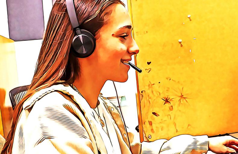 Young woman wearing a headset and using a computer