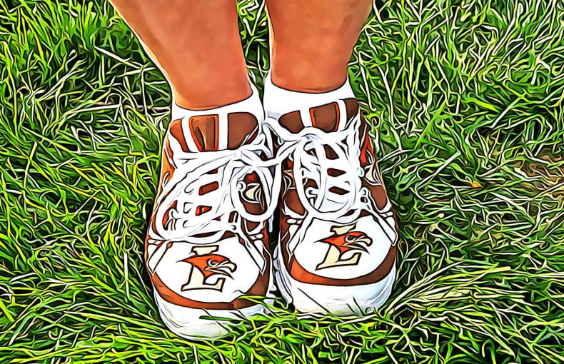 Brown and white sneakers sporting the "L Hawk" athletics logo