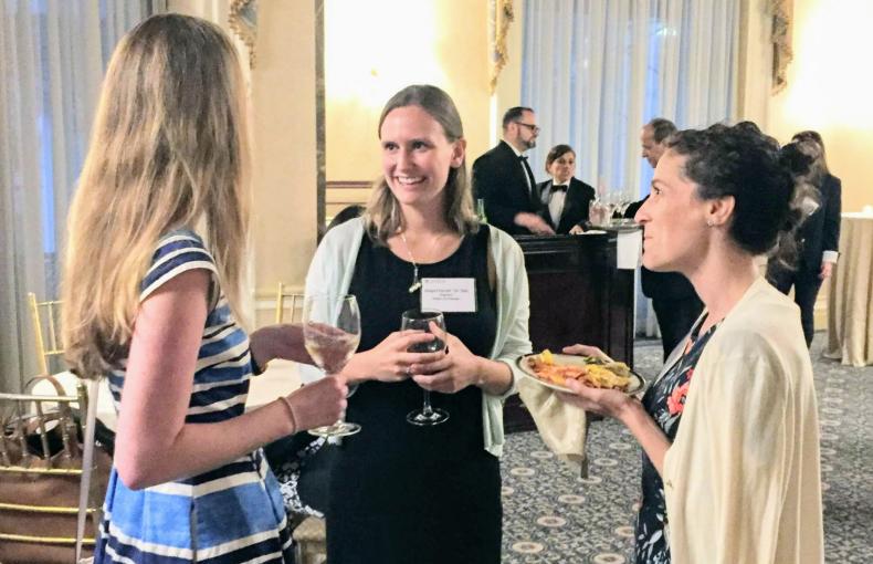 Three women chatting over food and drinks