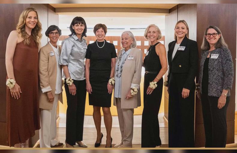 Women inducted into the Athletics Hall of Fame standing before the archway to the Hall.