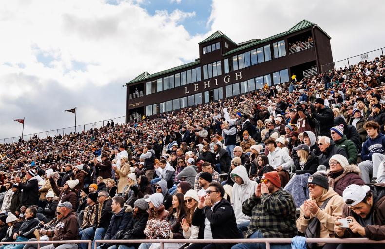 Fans cheering in the stands of Goodman Stadium sporting their brown and white attire.