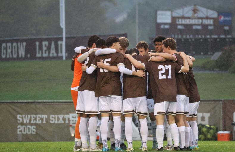 The Men's Soccer team at Lehigh University huddle on the field.