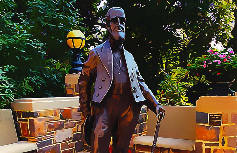 The Asa Packer Statue surrounded by benches and trees.