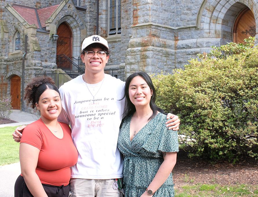 Three students stand close together near Packer Memorial Chapel