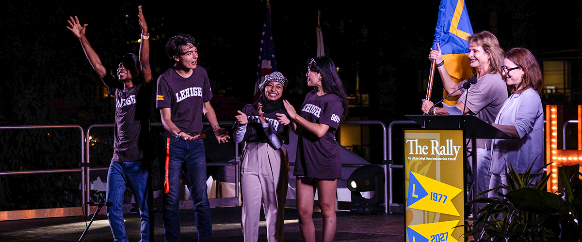 First-year Lehigh University students on stage with an alumni volunteer and staff at The Rally outdoor celebration.