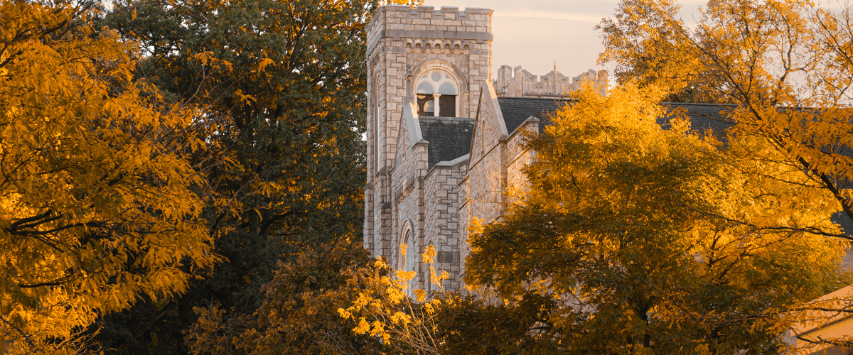 Exterior view of a stone building at Lehigh University surrounded by yellow fall folliage.