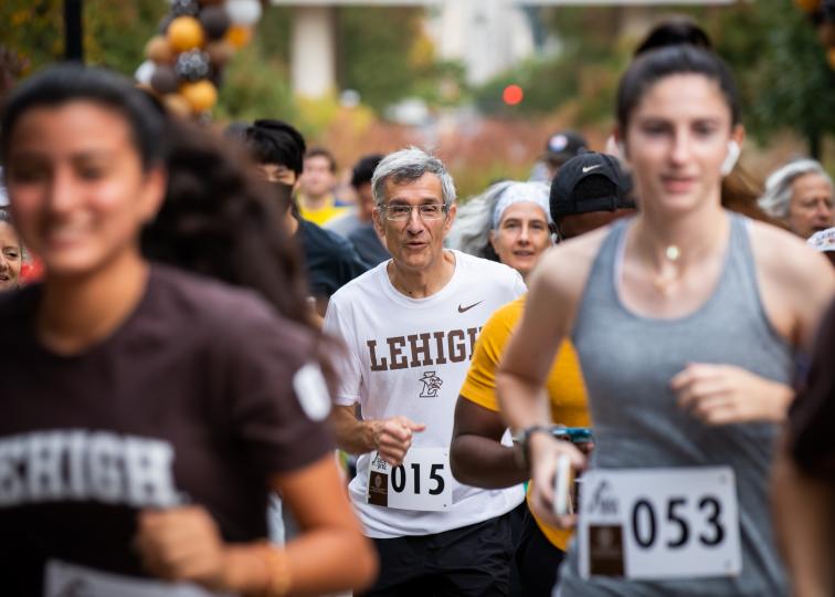 President Helble running during a Pace the Prez on campus
