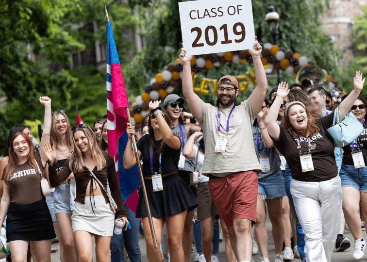 Class of 2019 parades at reunion holding a sign with their class year