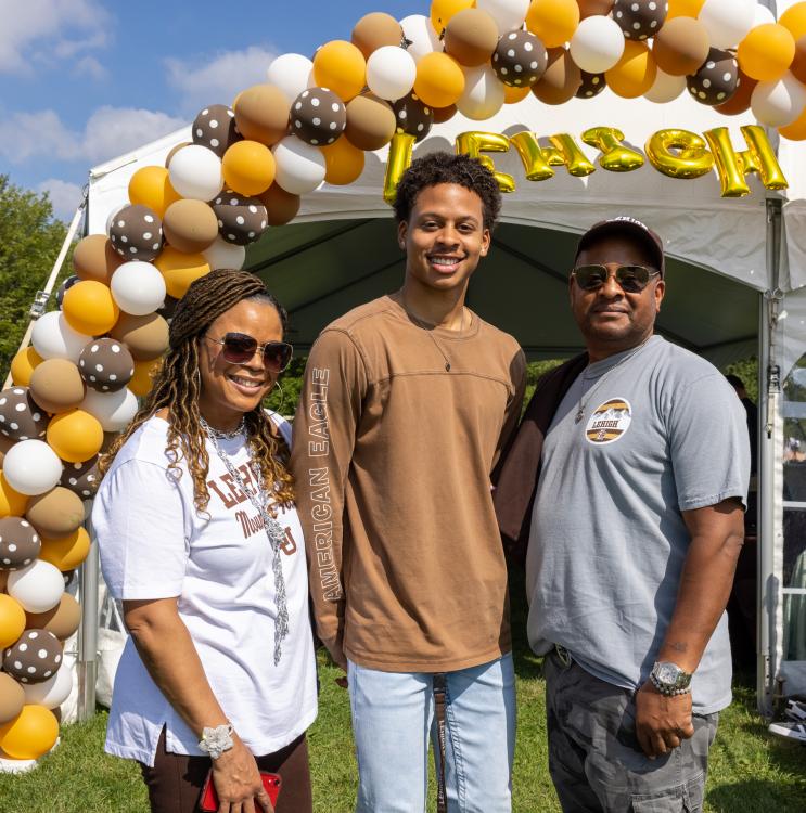 Family standing under a balloon arch