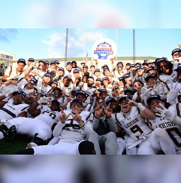 Lehigh football players in white uniforms poise for a group photo and hold a "Patriot League Champions" sign