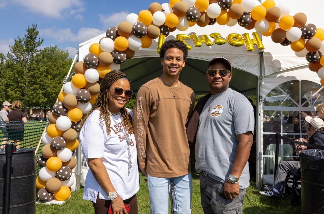 Family standing under a balloon arch